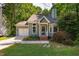Charming home features a manicured lawn, shrubbery, garage, and mature trees at 4117 Olde Coach Rd, Durham, NC 27707