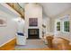 Bright living room featuring a fireplace, high ceilings, large windows, and hardwood floors at 4117 Olde Coach Rd, Durham, NC 27707