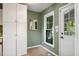 Green-walled mud room with ceramic tile flooring and white storage cabinets at 4117 Olde Coach Rd, Durham, NC 27707