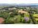 Expansive aerial view of a property featuring lush greenery, a serene pond, and farmland at 4345 Mcintyre Rd, Gibsonville, NC 27249