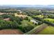 Expansive aerial view of a property featuring lush greenery, a serene pond, and farmland at 4345 Mcintyre Rd, Gibsonville, NC 27249