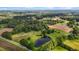 Expansive aerial view of a property featuring lush greenery, a serene pond, and farmland at 4345 Mcintyre Rd, Gibsonville, NC 27249