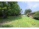 Expansive backyard with lush greenery, featuring a playset, mature trees, and a view of the home's exterior at 4345 Mcintyre Rd, Gibsonville, NC 27249