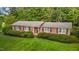 Charming brick home featuring black shutters, manicured landscaping, and lush green lawn at 4345 Mcintyre Rd, Gibsonville, NC 27249