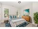 Decorated bedroom featuring carpet, two windows, a bed, and modern decor at 454 Martins Mill Ct, Wendell, NC 27591