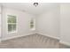 Bright bedroom featuring carpet and two windows with a view of the outdoors at 454 Martins Mill Ct, Wendell, NC 27591