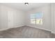 Simple, carpeted bedroom with a window allowing natural light and neutral-toned walls at 454 Martins Mill Ct, Wendell, NC 27591