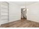 Empty dining room with hardwood floors, chandelier, wainscoting, built-in shelving, and view of a staircase at 454 Martins Mill Ct, Wendell, NC 27591