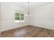 Dining room with hardwood floors, large window, elegant chandelier, and decorative wall trim at 454 Martins Mill Ct, Wendell, NC 27591