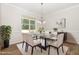 Dining room featuring hardwood floors, a chandelier, a glass-top table, and six upholstered chairs at 454 Martins Mill Ct, Wendell, NC 27591