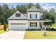 Charming two-story home with white siding, black shutters, a two-car garage, and a well-manicured lawn at 454 Martins Mill Ct, Wendell, NC 27591