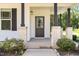 A close-up of the front porch with brick columns, a dark front door and tasteful landscaping at 454 Martins Mill Ct, Wendell, NC 27591