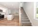 Sunlit open floor plan with wood floors, island kitchen, and staircase to the upper level at 454 Martins Mill Ct, Wendell, NC 27591