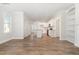 Spacious open floor plan with wood floors and a kitchen featuring white cabinets and stainless steel appliances at 454 Martins Mill Ct, Wendell, NC 27591