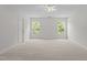 This bright bedroom features a ceiling fan and large windows that let in natural light at 4716 Miller Dr, Durham, NC 27704