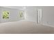 Spacious bedroom with ample natural light from two windows and neutral colored carpet at 4716 Miller Dr, Durham, NC 27704