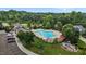 Aerial view of a large community pool and clubhouse with ample parking and a playground at 4716 Miller Dr, Durham, NC 27704