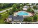 Aerial view of a large community pool and clubhouse with ample parking surrounded by trees and landscaping at 4716 Miller Dr, Durham, NC 27704