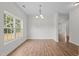 A dining room featuring hardwood floors, a modern chandelier, and a view of the lawn at 4716 Miller Dr, Durham, NC 27704