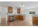 Well-equipped kitchen featuring stainless steel dishwasher, granite countertops, and wood cabinets at 4716 Miller Dr, Durham, NC 27704