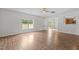 Well-lit living room features wood-look flooring, a ceiling fan, and large windows offering a comfortable atmosphere at 4716 Miller Dr, Durham, NC 27704
