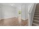 Bright living room with hardwood floors, a window overlooking the lawn, and staircase at 4716 Miller Dr, Durham, NC 27704