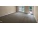 A spacious bedroom with neutral carpet, a door to a balcony, and a window at 495 Ruth Cir, Fuquay Varina, NC 27526