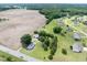 A high angle aerial view of the home on a spacious lot with a field and a residential area nearby at 5004 Us 70 Alt, Princeton, NC 27569