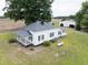Classic white farmhouse with a metal roof, side patio, and a lush green lawn at 5004 Us 70 Alt, Princeton, NC 27569