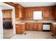 Kitchen with wood cabinetry and adjoining room featuring brick fireplace at 5004 Us 70 Alt, Princeton, NC 27569