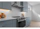 Close-up of the modern kitchen featuring sleek blue cabinets, white countertops, and stainless steel appliances at 505 Colleton Rd, Raleigh, NC 27610