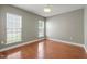 Bright bedroom with wood floors, natural light from two windows, and modern ceiling light at 621 Aylestone Dr, Cary, NC 27519