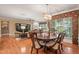 Open concept dining area featuring wood floors, round table and chairs and a view into the living room with fireplace at 621 Aylestone Dr, Cary, NC 27519