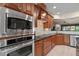 Updated kitchen boasts stainless steel appliances, custom wood cabinets, tile backsplash, and granite countertops at 621 Aylestone Dr, Cary, NC 27519