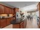 Spacious kitchen with granite island, stainless steel appliances, wood cabinets, and view into the breakfast nook at 621 Aylestone Dr, Cary, NC 27519