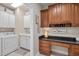 Functional laundry room with built-in cabinets, sink, and workspace on the main level at 621 Aylestone Dr, Cary, NC 27519