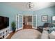 Comfortable living room with light blue walls, modern light, french doors and beautiful hardwood floors at 621 Aylestone Dr, Cary, NC 27519