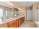 Double sink with wood cabinetry in a bathroom with tiled floor and framed mirrors at 621 Aylestone Dr, Cary, NC 27519