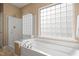 Bright bathroom featuring a glass shower, soaking tub, and frosted glass window at 621 Aylestone Dr, Cary, NC 27519
