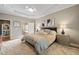 Large main bedroom featuring tray ceilings, fan, plush carpeting and connecting bathroom at 621 Aylestone Dr, Cary, NC 27519