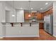 Kitchen with stainless steel appliances, wooden cabinetry, granite countertops and bar top seating at 8323 Yaxley Hall Dr, Raleigh, NC 27616