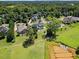 Expansive aerial view of this private estate showcasing the neighborhood, lush landscaping, and inground irrigation pond at 940 Rivers Edge Dr, Graham, NC 27253