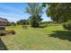 Expansive back yard featuring mature shade trees, lush lawn, and flowering bushes at 940 Rivers Edge Dr, Graham, NC 27253