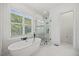 Bright bathroom with a free-standing tub and glass enclosed shower, next to a large window at 940 Rivers Edge Dr, Graham, NC 27253