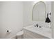 This bathroom features a modern sink and toilet with white walls and an arched mirror at 940 Rivers Edge Dr, Graham, NC 27253