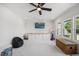 Bright bonus room featuring plush carpet, ceiling fan, built in storage, and natural light from the oversized windows at 940 Rivers Edge Dr, Graham, NC 27253