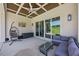 Relaxing covered patio with vaulted ceiling, cooling fan, lounge seating, and peaceful views of the backyard at 940 Rivers Edge Dr, Graham, NC 27253