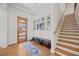 Bright foyer featuring hardwood floors, staircase, console table, and decorative door at 940 Rivers Edge Dr, Graham, NC 27253