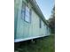 Exterior view of a single-story home with faded green siding and overgrown grass at , Cameron, NC 28326