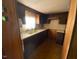 Galley kitchen with linoleum flooring, matching countertops, and dark cabinets at , Cameron, NC 28326